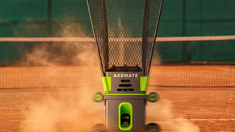 Tennis ball machine moving across a clay court with dust in the air