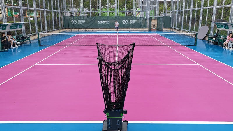 Acemate tennis ball machine set up on a bright hard court for solo tennis practice